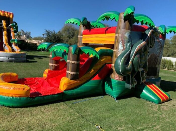 dinosaur-themed inflatable bounce house with a slide