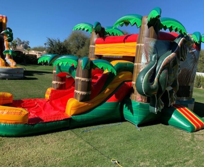 dinosaur-themed inflatable bounce house with a slide